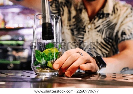 bartender preparing mojito cocktail drink in bar