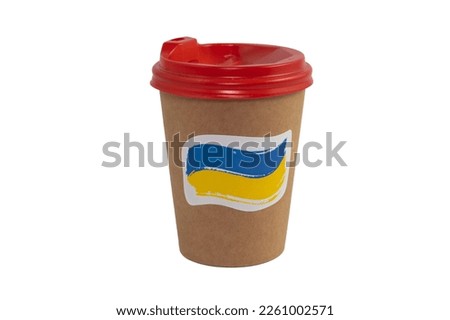 Disposable paper cup of coffee with a sticker in the form of the national flag of Ukraine, isolated on a white background (close-up)
