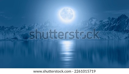 Knud Rasmussen Glacier near Kulusuk - Greenland, East Greenland - Night sky with blue moon in the clouds over the calm blue sea "Elements of this image furnished by NASA