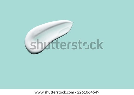 Skin care cream, face serum swatch smear on green background. Skincare product creamy texture smudge swipe closeup.  Royalty-Free Stock Photo #2261064549