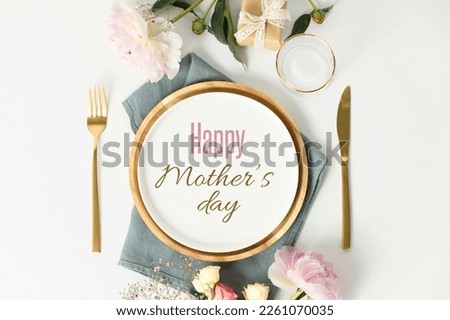 Happy Mother's day concept. Beautiful table setting with golden cutlery and peony flowers, flat lay Royalty-Free Stock Photo #2261070035