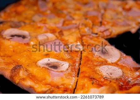 Pizza baked for young people with ham, fresh and pickled champignons, cheese