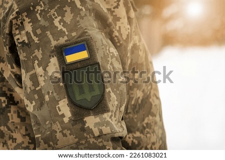 Ukraine Army Background. Ukrainian flag Symbol on Soldier Camouflage Uniform. Soldier of the Ukrainian Armed Forces. Victory concept. Copy Space. 