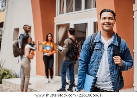 Young hispanic student smiling happy wearing a backpack at the university. Royalty-Free Stock Photo #2261086061