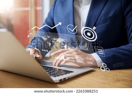 Businessman analyzing company's financial balance sheet working with digital augmented reality graphics. Businessman calculates financial data for long-term investment. Royalty-Free Stock Photo #2261088251