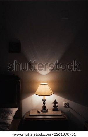 Lamp on bedside table in the dark. Royalty-Free Stock Photo #2261090751