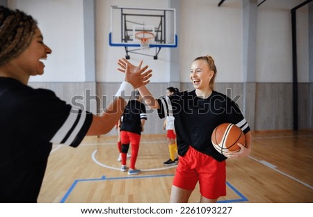 Women, sports team players, in gym celebrating victory.