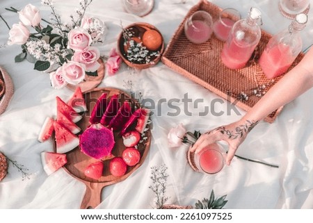 Summer picnic concept on sunny day with healthy fresh tropical fruits on a white blanket
