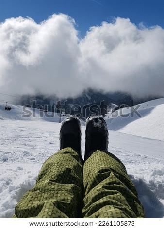 Legs of a snowboarder against the backdrop of mountains. High quality photo