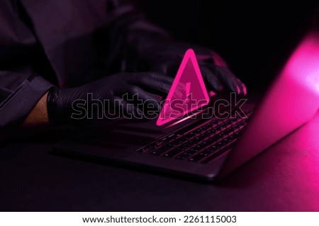 Hacker using laptop computer with triangle warning sign for error search and financial business data search concept