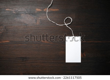 Blank price tag mockup on wood table background. Template for graphic designers portfolios. Flat lay.