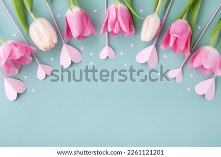 Bouquet of beautiful spring flowers and pink hearts on pastel blue table top view. Greeting card for 8 March International Women Day, Mother day. Flat lay.