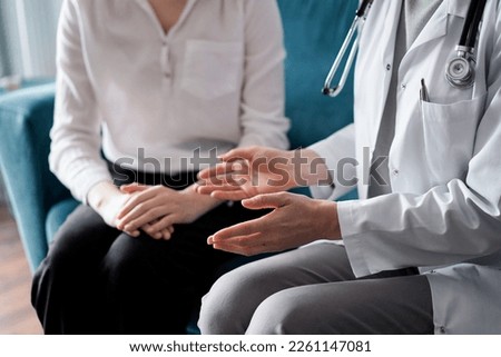 Doctor and patient discussing current health examination while sitting at the desk in clinic office, closeup. Medicine concept. Royalty-Free Stock Photo #2261147081