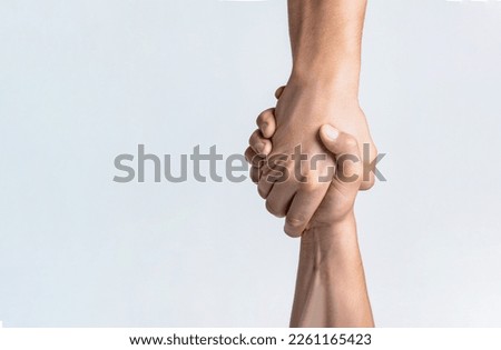 Friendly handshake, friends greeting, teamwork, friendship. Close-up. Rescue, helping gesture or hands. Strong hold. Two hands, helping hand of a friend. Handshake, arms friendship Royalty-Free Stock Photo #2261165423