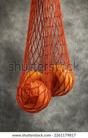 Red net shopping bag with oranges. Close up.