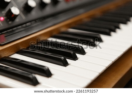 Black and white piano keys on modern synthesizer. Professional electronic synth device in sound recording studio Royalty-Free Stock Photo #2261193257