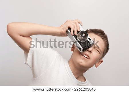 Young artist with retro camera during a shooting process