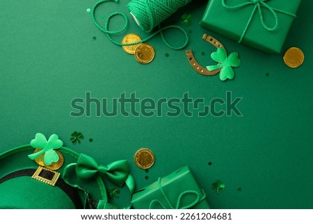 Saint Patrick's Day concept. Top view photo of leprechaun hat present boxes spool of twine gold coins bow-tie horseshoe clovers and confetti on isolated green background with copyspace Royalty-Free Stock Photo #2261204681
