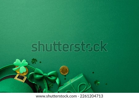 Saint Patrick's Day concept. Top view photo of leprechaun hat giftbox with bow gold coins bow-tie clover and trefoil shaped confetti on isolated green background with empty space