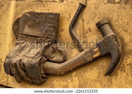 close up of old dirty vintage work gloves and broken hammer and nail 