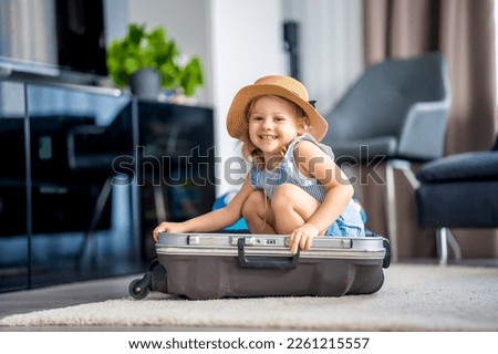 Little girl with suitcase baggage luggage ready to go for traveling on vacation. High quality photo