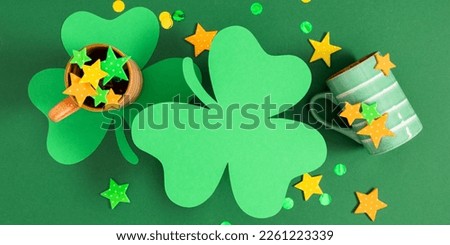 Saint Patricks Day composition, party background. Holiday decoration for St. Patrick's day, mug, green paper clover leaf, confetti on green background. Flat lay, top view, copy space