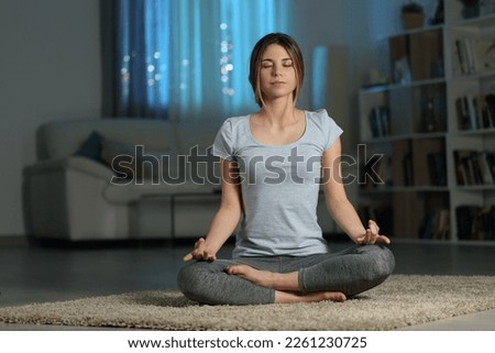 Front view portrait of a yogi doing yoga in the night at home Royalty-Free Stock Photo #2261230725