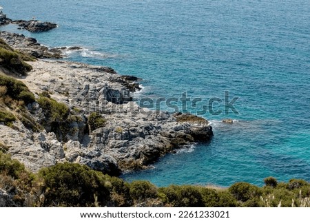 Bird's eye view of the blue sea, rocks in clear water, azure beach. Beautiful landscape of the sea coast, stones in blue water, waves