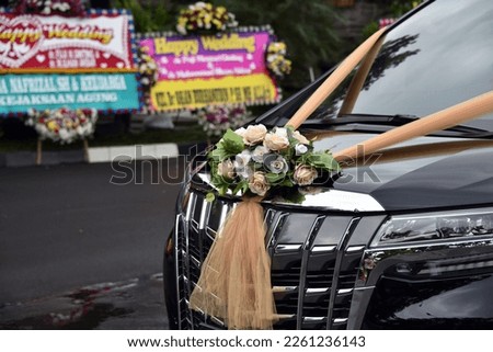 The wedding car with ribbon flowers