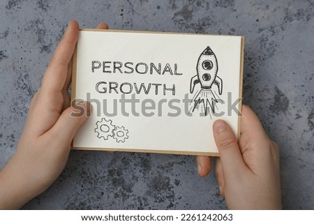 Person hands hold white card with phrase Personal Growth Royalty-Free Stock Photo #2261242063