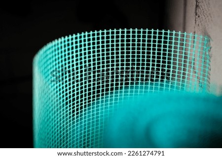 Green reinforcing mesh close-up. Facade fiberglass mesh on a blurred background Royalty-Free Stock Photo #2261274791
