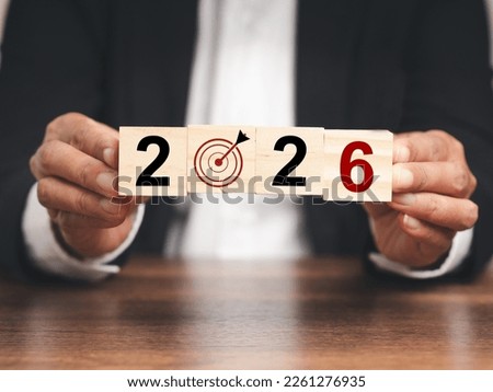 Business planning and strategy and countdown to 2026. Hands businessman holding wooden cubes with the letters 2026 while sitting at the table in the office Royalty-Free Stock Photo #2261276935