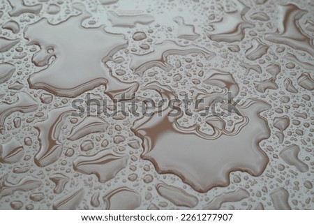Raindrops collect and form various shapes.