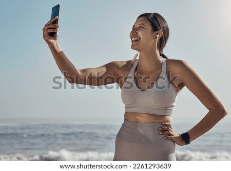 Fitness, selfie and woman at the beach for yoga, training and workout on blue sky background. Social media, live streaming and exercise influencer female recording for blog, post or profile picture