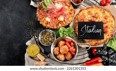 Dinner table of italian meals dishes.  Pizza, pasta, antipasto  on black background. Healthy eating concept. Top view, copy space