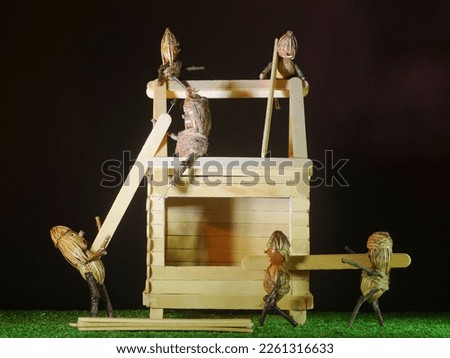 mini figures act like team work building a house