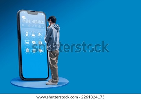 Smart student using a big smartphone with online education app interface, he is choosing a subject, e-learning concept Royalty-Free Stock Photo #2261324175