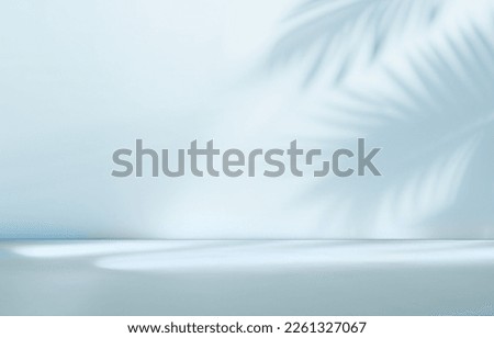 Blurred shadow from palm leaves on the light blue wall. Minimal abstract background for product presentation. Spring and summer. Royalty-Free Stock Photo #2261327067