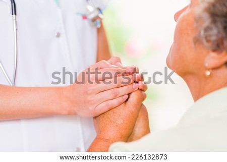 Photo of the young doctor hands protects the elderly woman hands