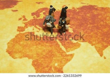 Miniature people toy figure photography. A group of refugee walking above map globe, moving out from their country because of war conflict. Distance traveled concept. Image photo