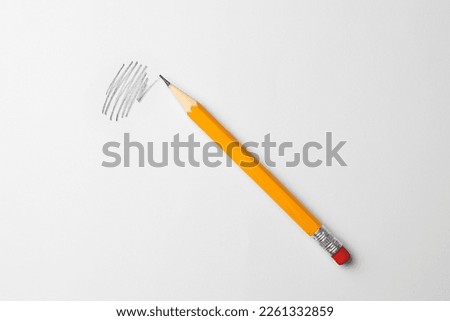 Sharp graphite pencil with eraser and hand drawn scribble on white sheet of paper, top view Royalty-Free Stock Photo #2261332859
