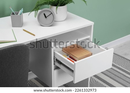 Office supplies in open desk drawer indoors Royalty-Free Stock Photo #2261332973