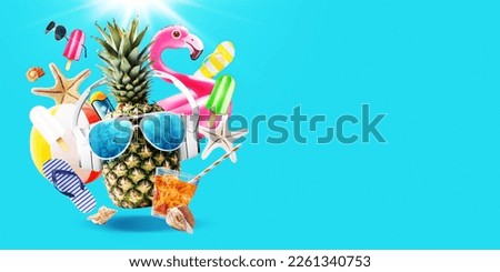 Cheerful funny pineapple wearing headphones and sunglasses surrounded by beach accessories and summer items, vacations and party concept