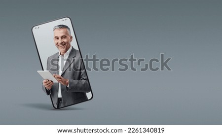 Cheerful confident businessman holding a digital tablet  in a smartphone videocall and smiling, online  service concept