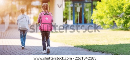 Girl and boy going to the school to study at it. Concept of back to school and friendship. Royalty-Free Stock Photo #2261342183