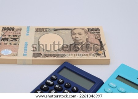 Japanese banknotes and calculator closeup.
Translation:Bank of Japan, 10000, Bank of Japan, common to all financial institutions, manufactured by the National Printing Bureau, Yukichi Fukuzawa.