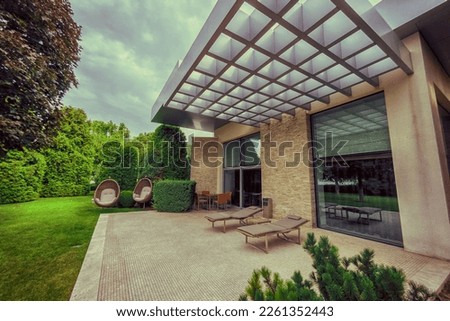 Luxury modern house with exotic terrace with wooden deck chair Royalty-Free Stock Photo #2261352443