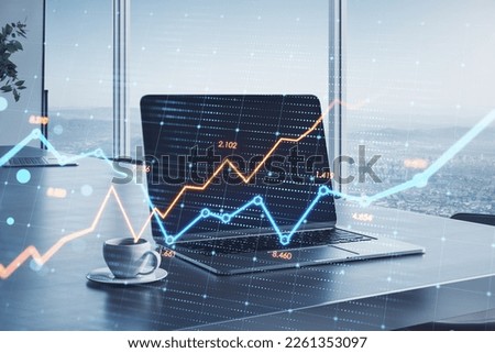 Close up of laptop on desktop with coffee cup and glowing business chart on blurry office background with window and city view. Stock, growth and financial graph concept. Double exposure