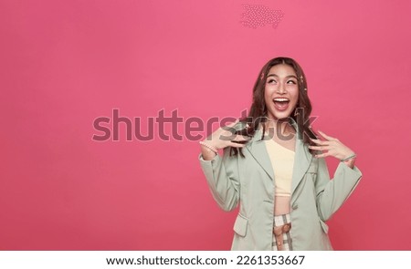Young Asian teenage girl surprised excited isolated on pink background. Royalty-Free Stock Photo #2261353667