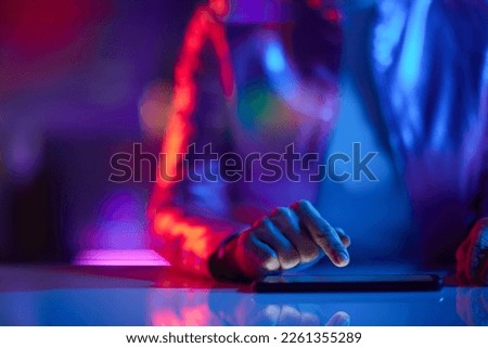 Neon metaverse futuristic concept. Closeup on business woman using smartphone applications in office.